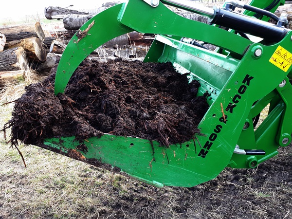 A tractor shovel with horse poop